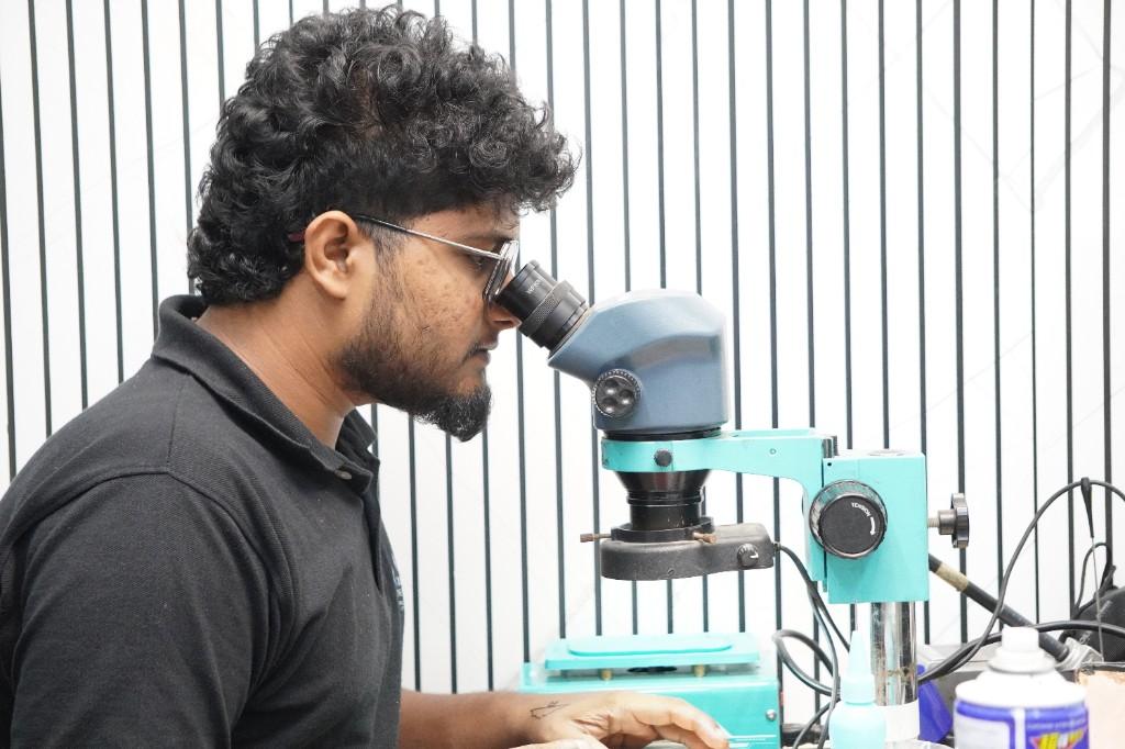 Board specialist at microscope doing microsoldering